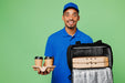 Smiling delivery man holding two coffees and a black insulated pizza carrier with two pizza boxes.