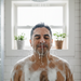hispanic man taking a shower and is cover in soap