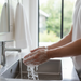 man washing hands in sink with suds
